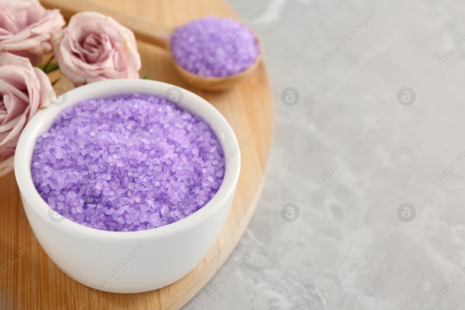 Photo of Sea salt and beautiful roses on light grey marble table, closeup. Space for text