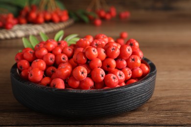 Photo of Plate with fresh ripe rowan berries on wooden table, closeup