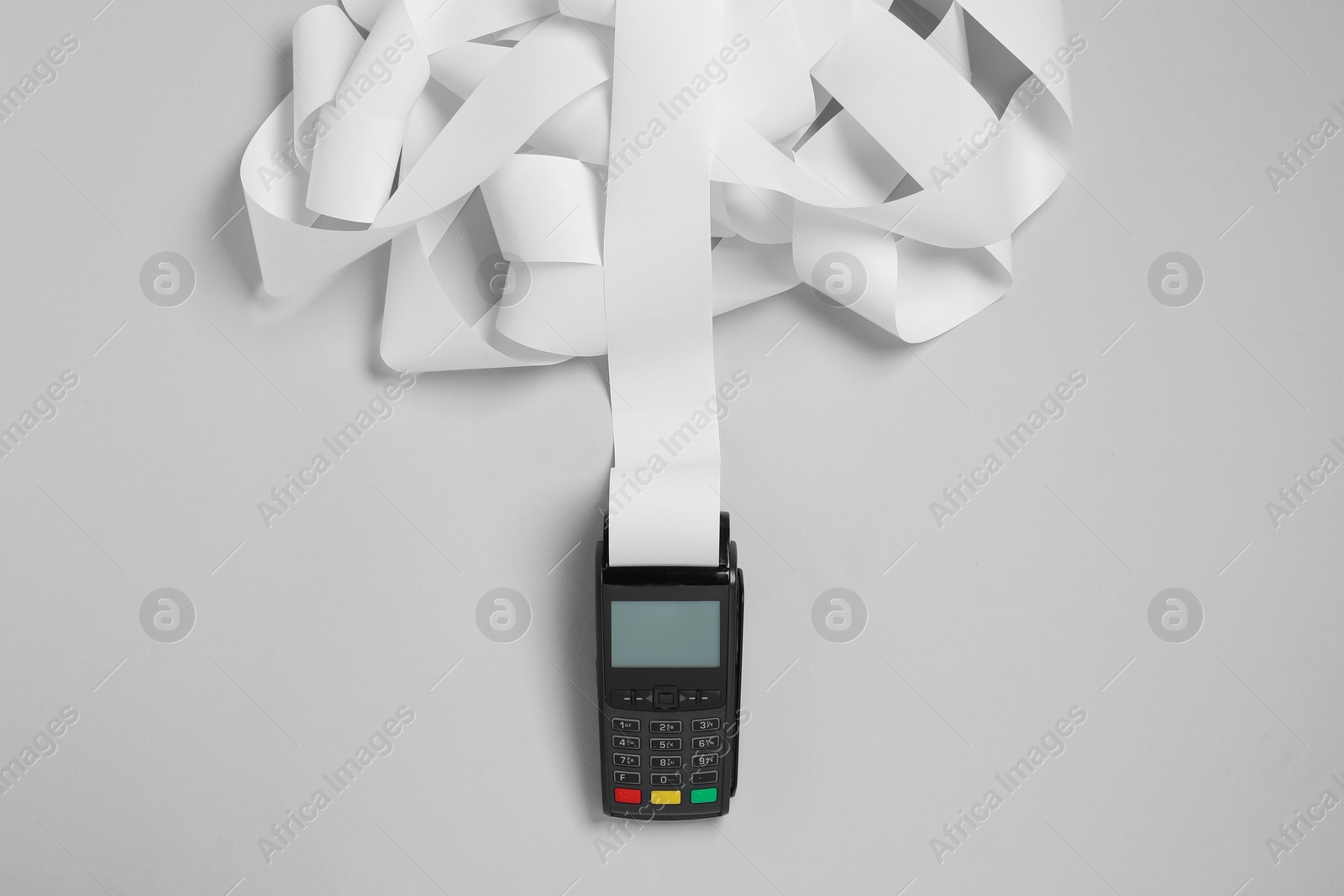 Photo of Payment terminal with thermal paper for receipt on light grey background, top view