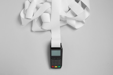 Payment terminal with thermal paper for receipt on light grey background, top view