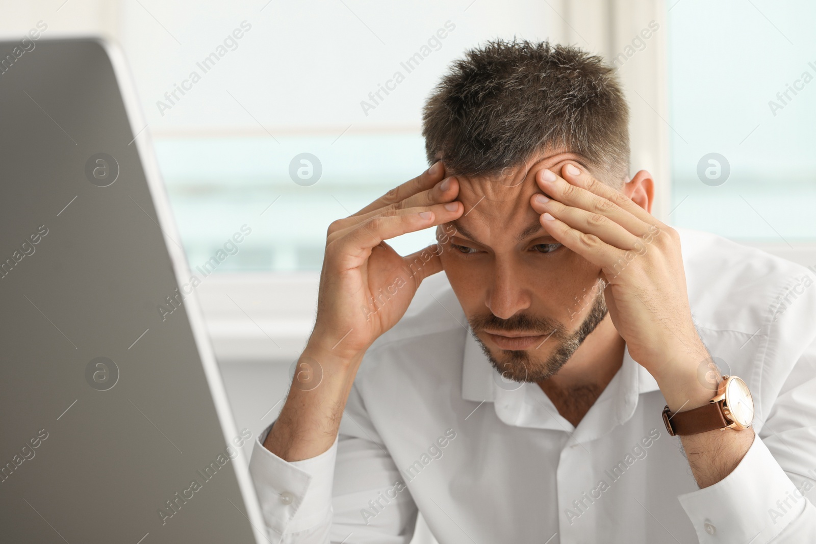 Photo of Sleep deprived man at workplace in office