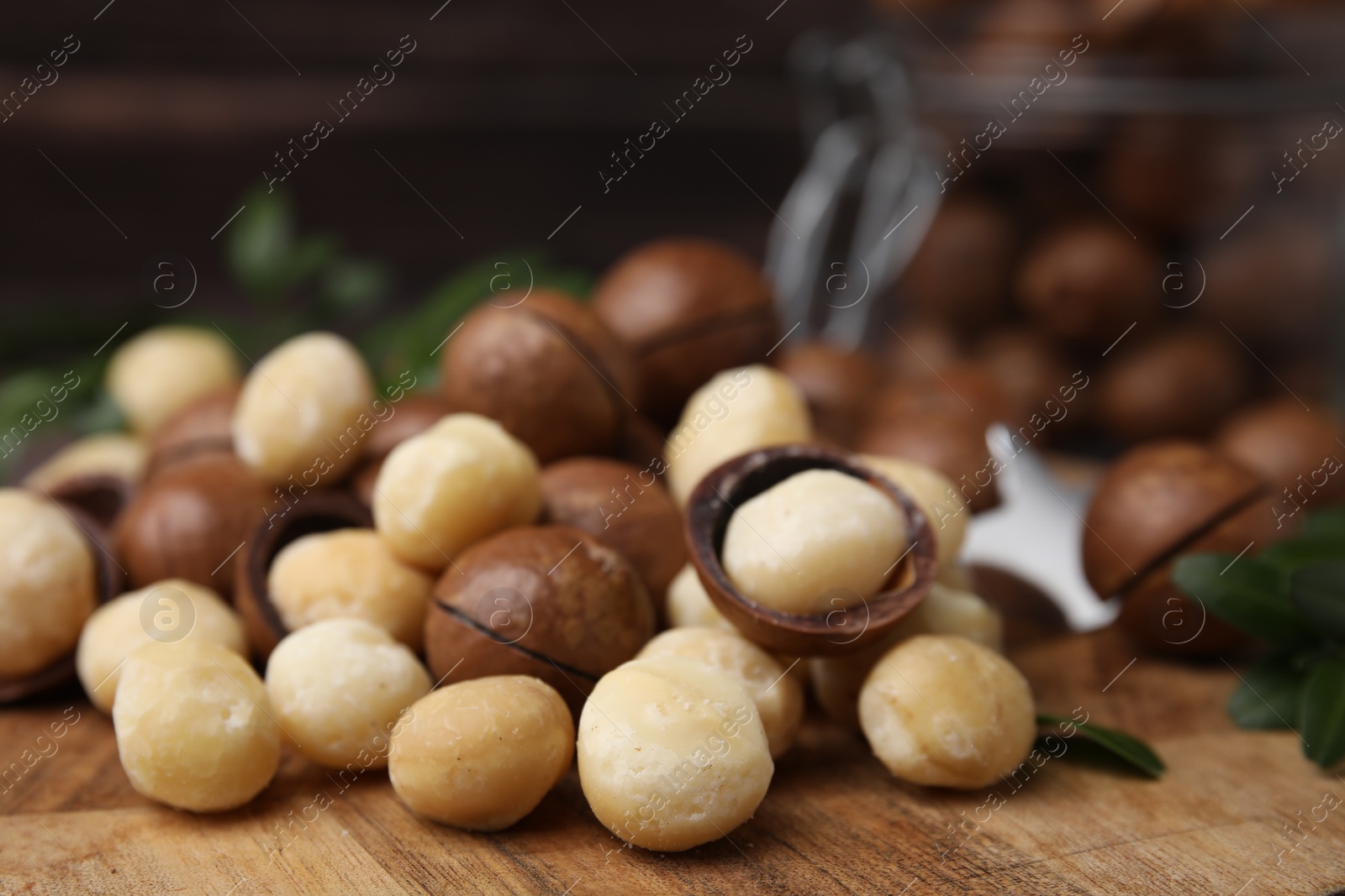 Photo of Tasty organic Macadamia nuts on wooden board, closeup