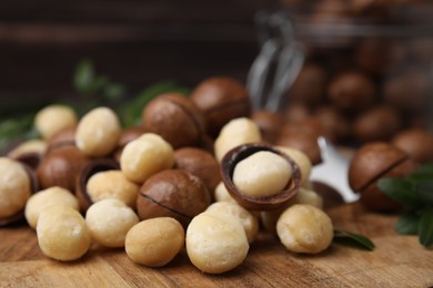 Photo of Tasty organic Macadamia nuts on wooden board, closeup