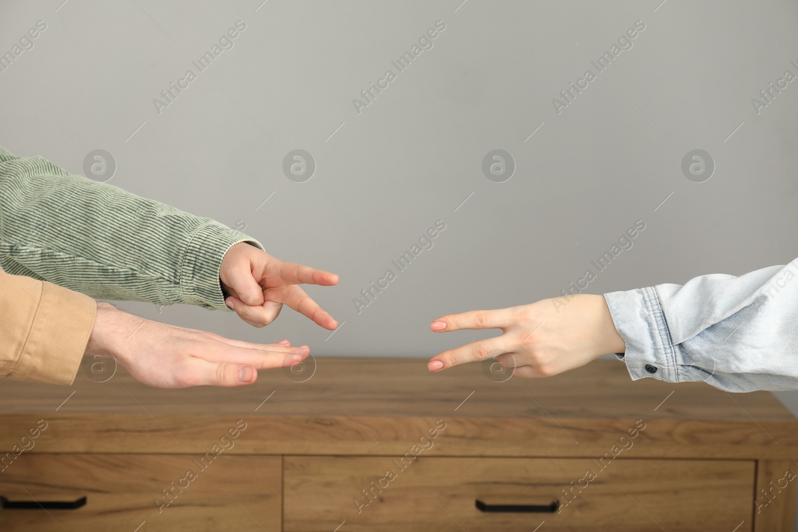 Photo of People playing rock, paper and scissors indoors, closeup