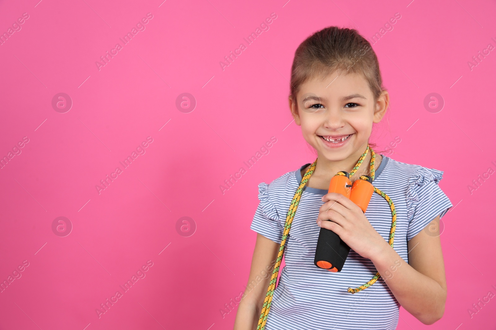 Photo of Cute girl with jump rope on color background. Space for text