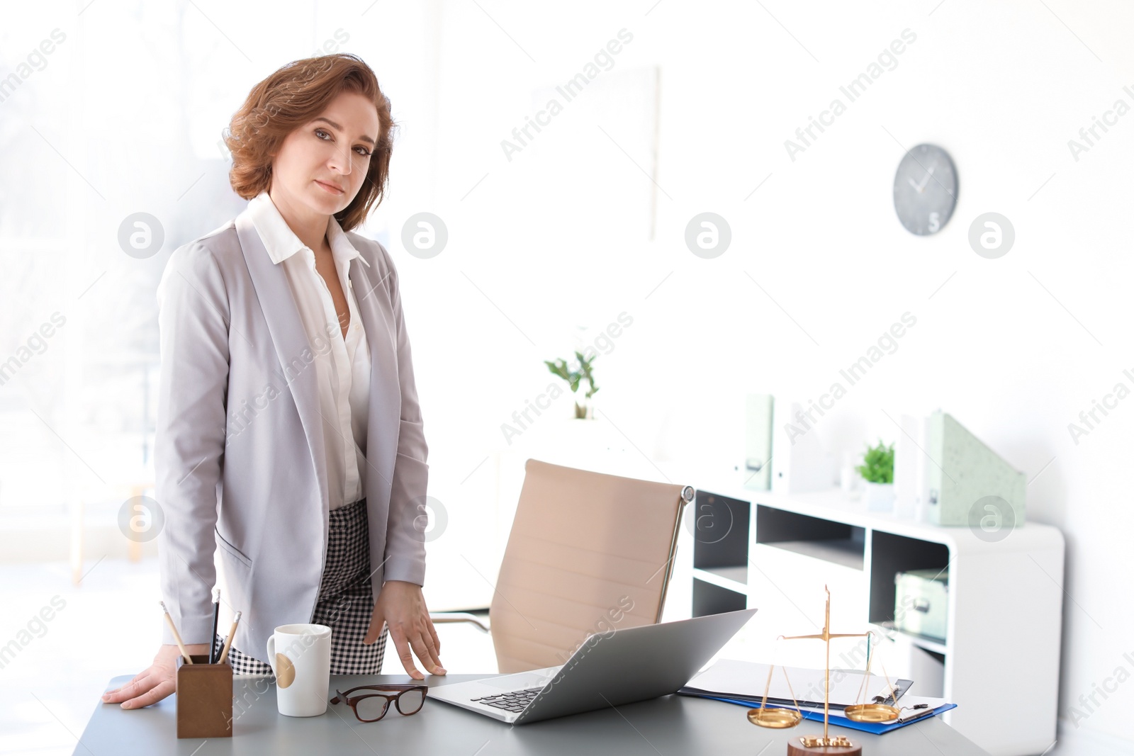 Photo of Female lawyer standing near table in office