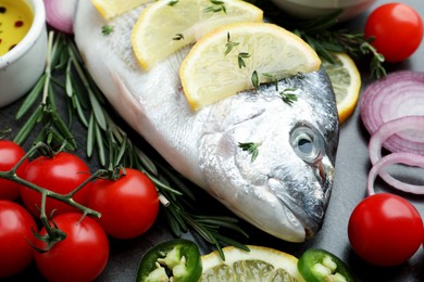 Fresh dorado fish and spices on black table, closeup