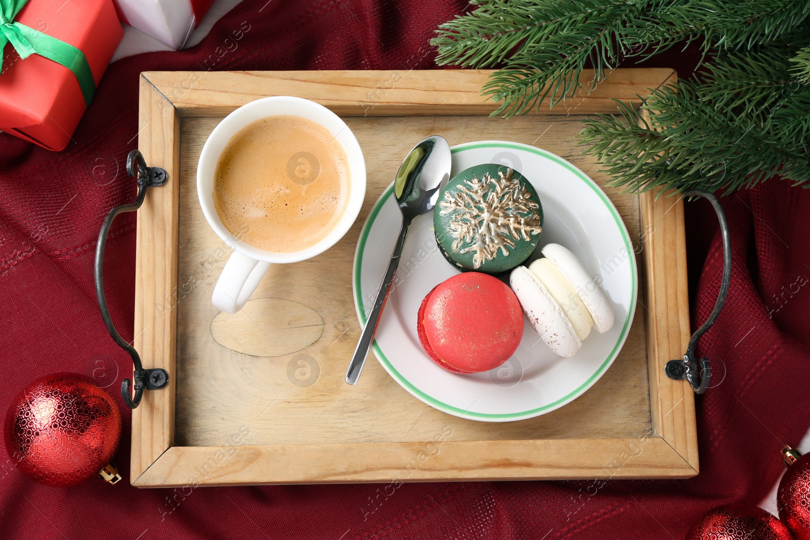 Photo of Different decorated Christmas macarons served with coffee on table, flat lay