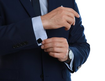 Stylish man putting on cufflink against white background, closeup