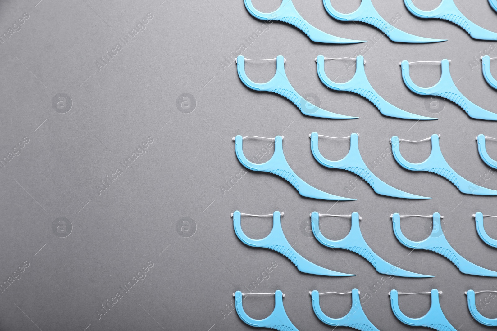 Photo of Flat lay composition with dental floss picks on grey background. Space for text