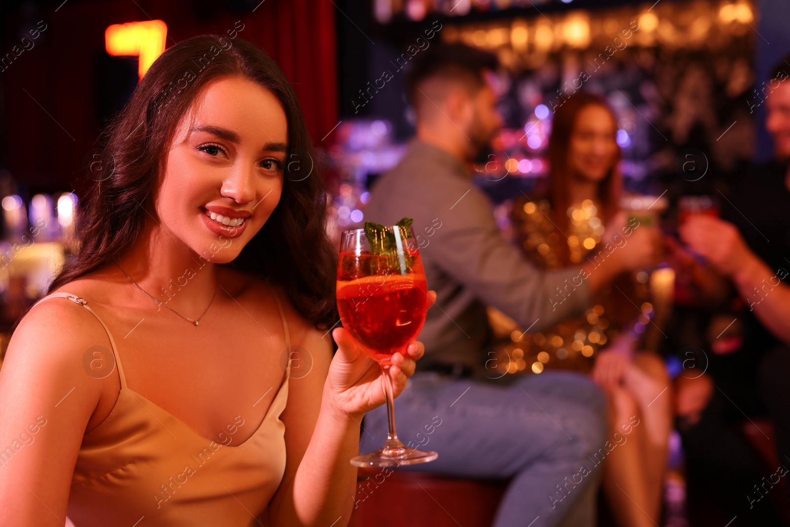 Photo of Friends spending time together in bar. Beautiful woman with fresh alcoholic cocktail, space for text