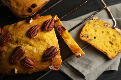 Delicious pumpkin bread with pecan nuts on black wooden table, flat lay