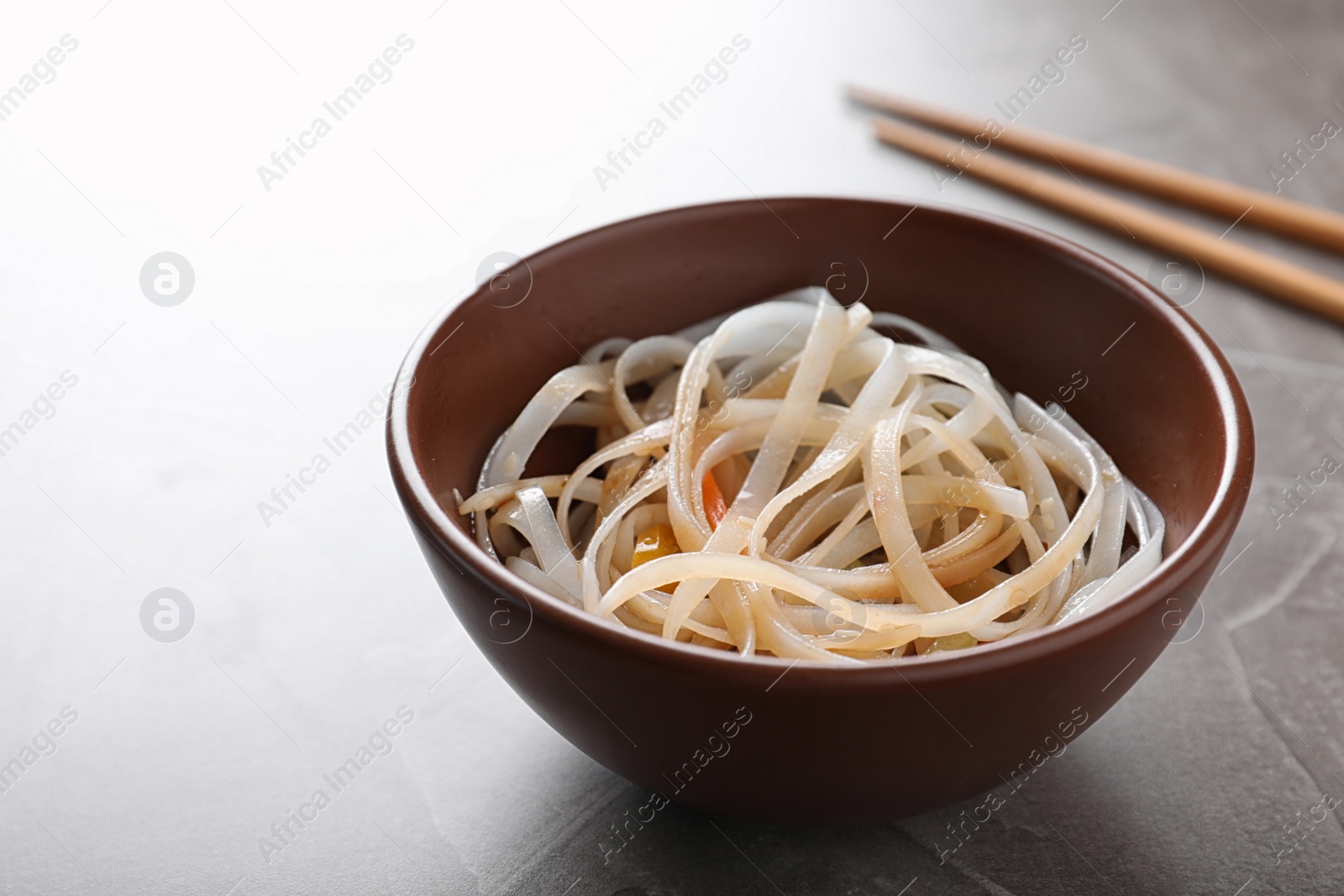 Photo of Bowl of delicious rice noodles on table