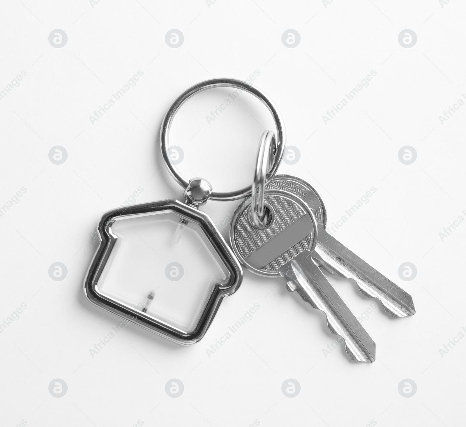 Photo of House keys with trinket on white background, top view