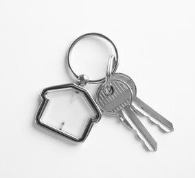 Photo of House keys with trinket on white background, top view