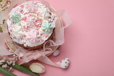 Photo of Traditional Easter cake with meringues and painted eggs on pink background, above view. Space for text