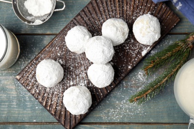 Photo of Flat lay composition with tasty Christmas snowball cookies on blue wooden table