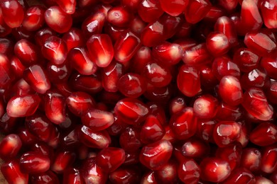 Photo of Ripe juicy pomegranate grains as background, top view