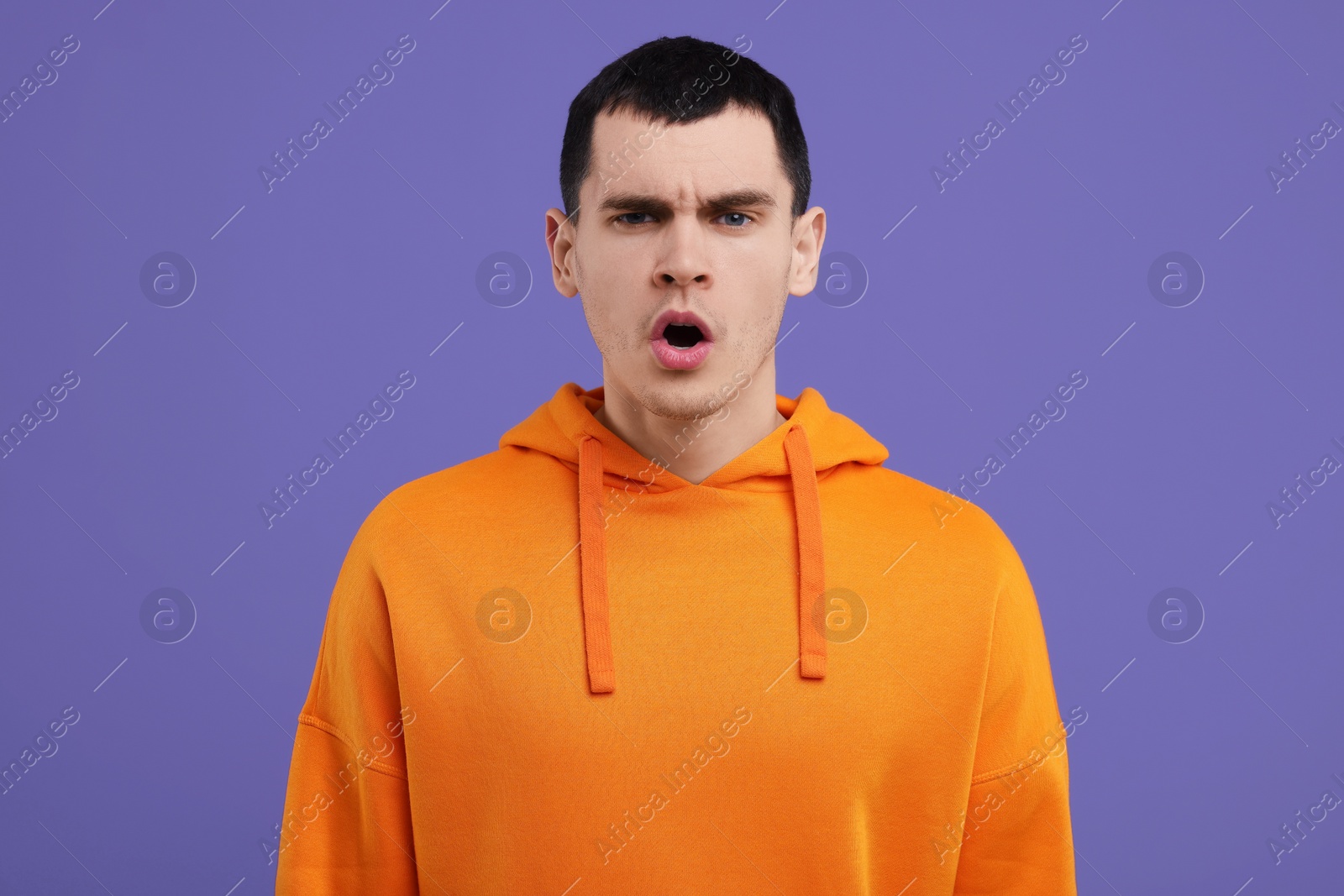 Photo of Portrait of surprised man on purple background