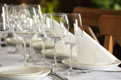 Table setting with empty glasses, plates and cutlery indoors