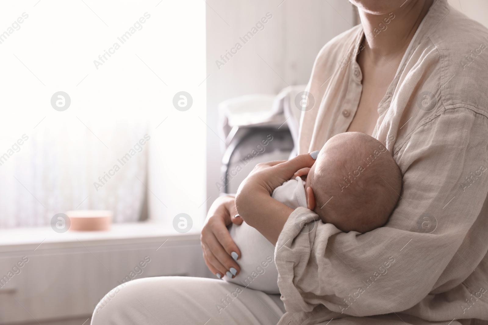 Photo of Mother holding her sleeping baby at home, closeup