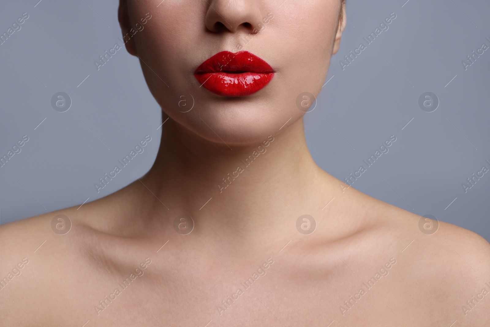 Photo of Closeup view of woman with beautiful full lips on grey background