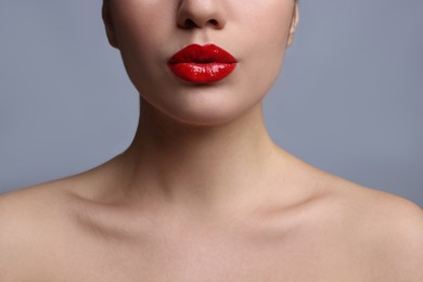 Photo of Closeup view of woman with beautiful full lips on grey background