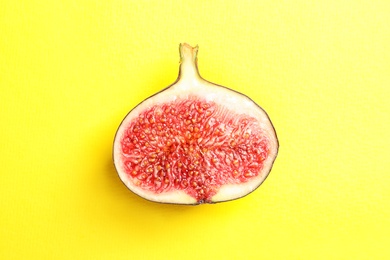 Photo of Half of ripe fig on color background, top view