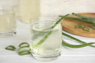 Photo of Fresh aloe drink on light wooden table, closeup