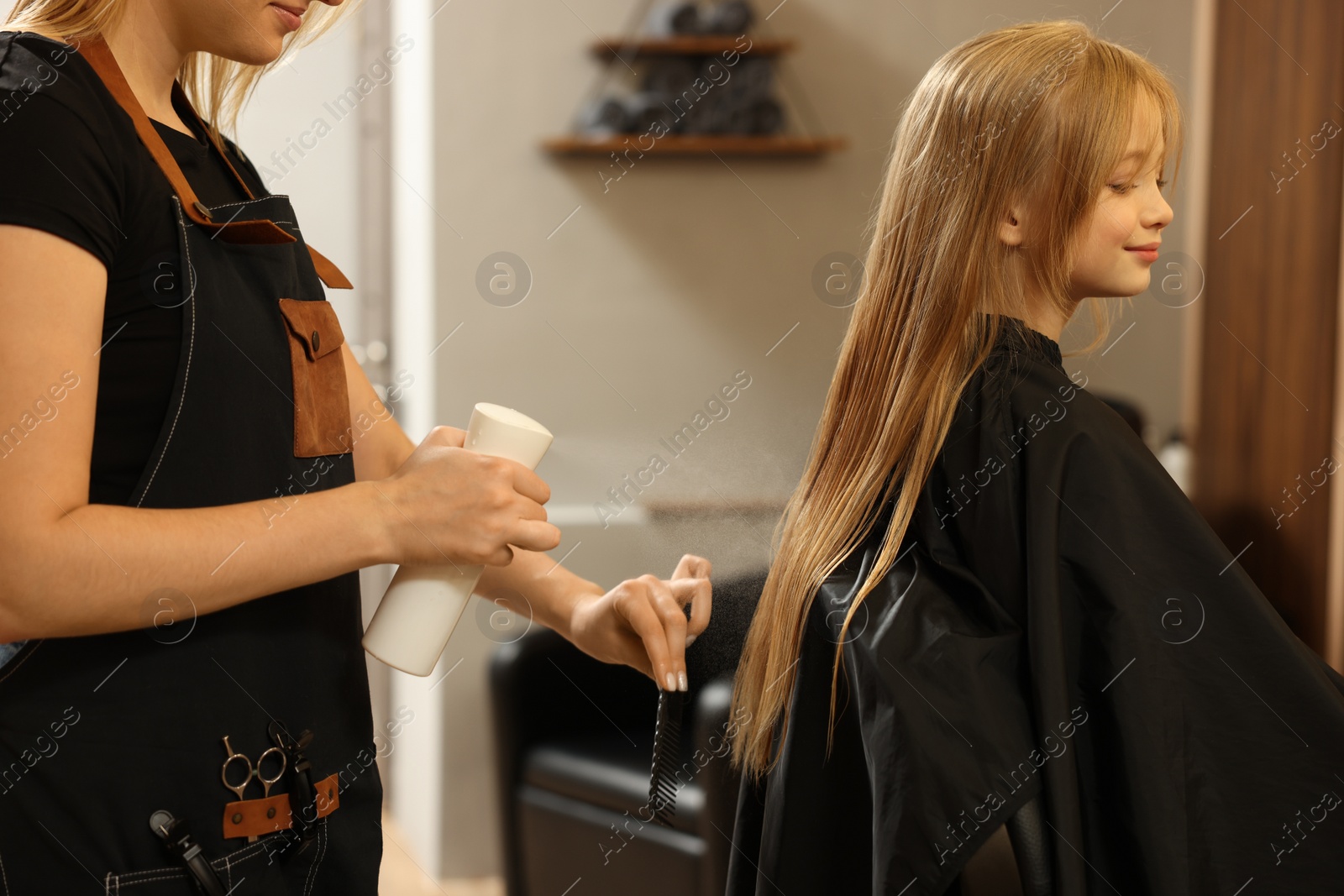 Photo of Professional hairdresser working with girl in beauty salon