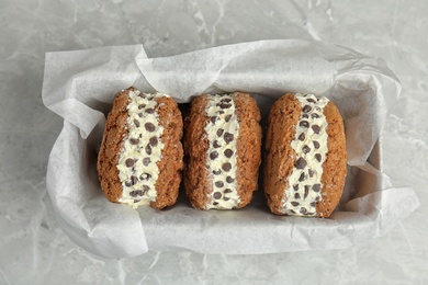 Photo of Sweet delicious ice cream cookie sandwiches with chocolate chips served on table, top view