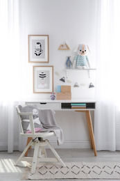 Stylish child's room interior with desk and beautiful pictures