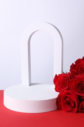 Stylish presentation for product. Geometric figures and roses on red table against white background