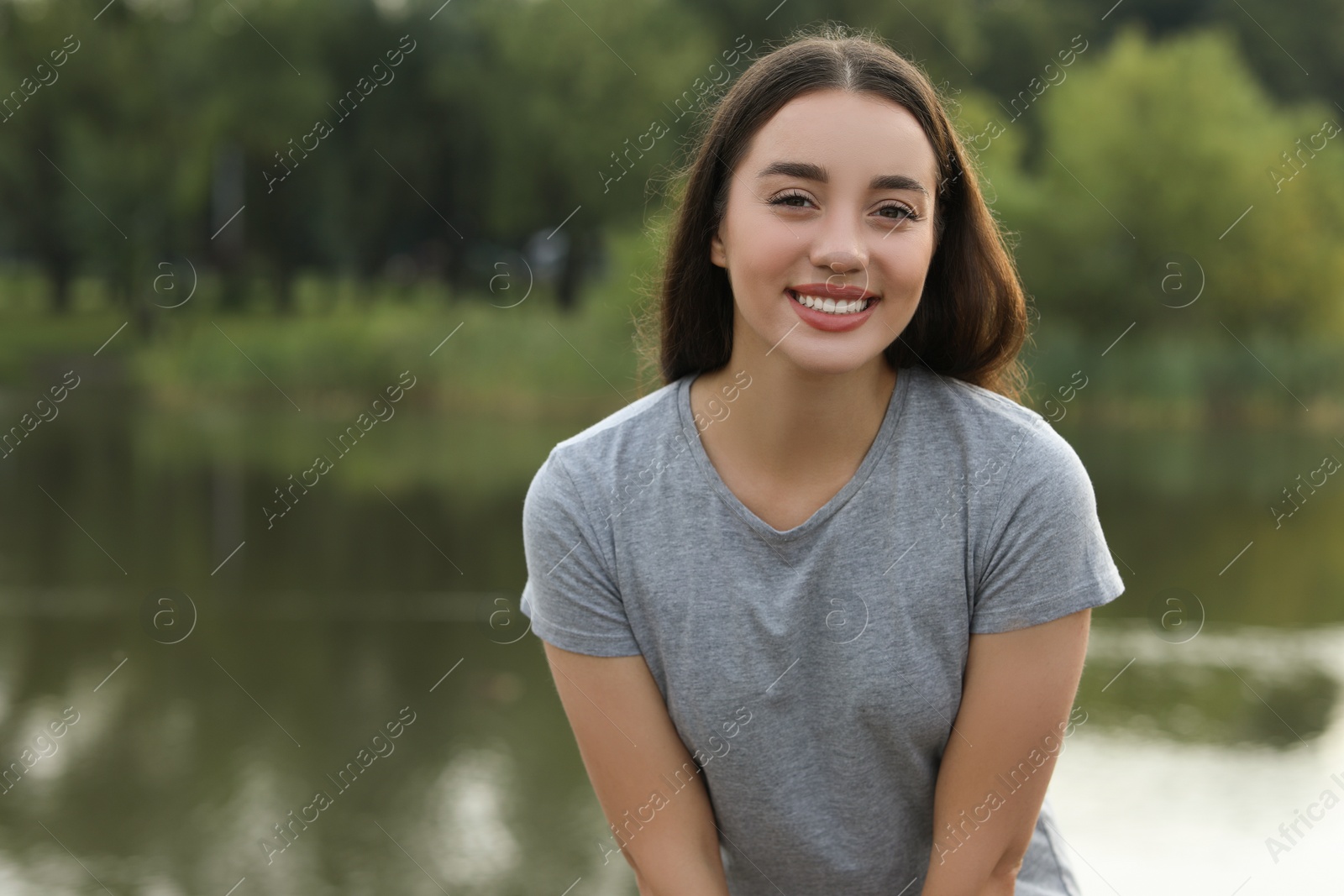 Photo of Portrait of beautiful woman outdoors. Attractive lady smiling and looking into camera. Space for text