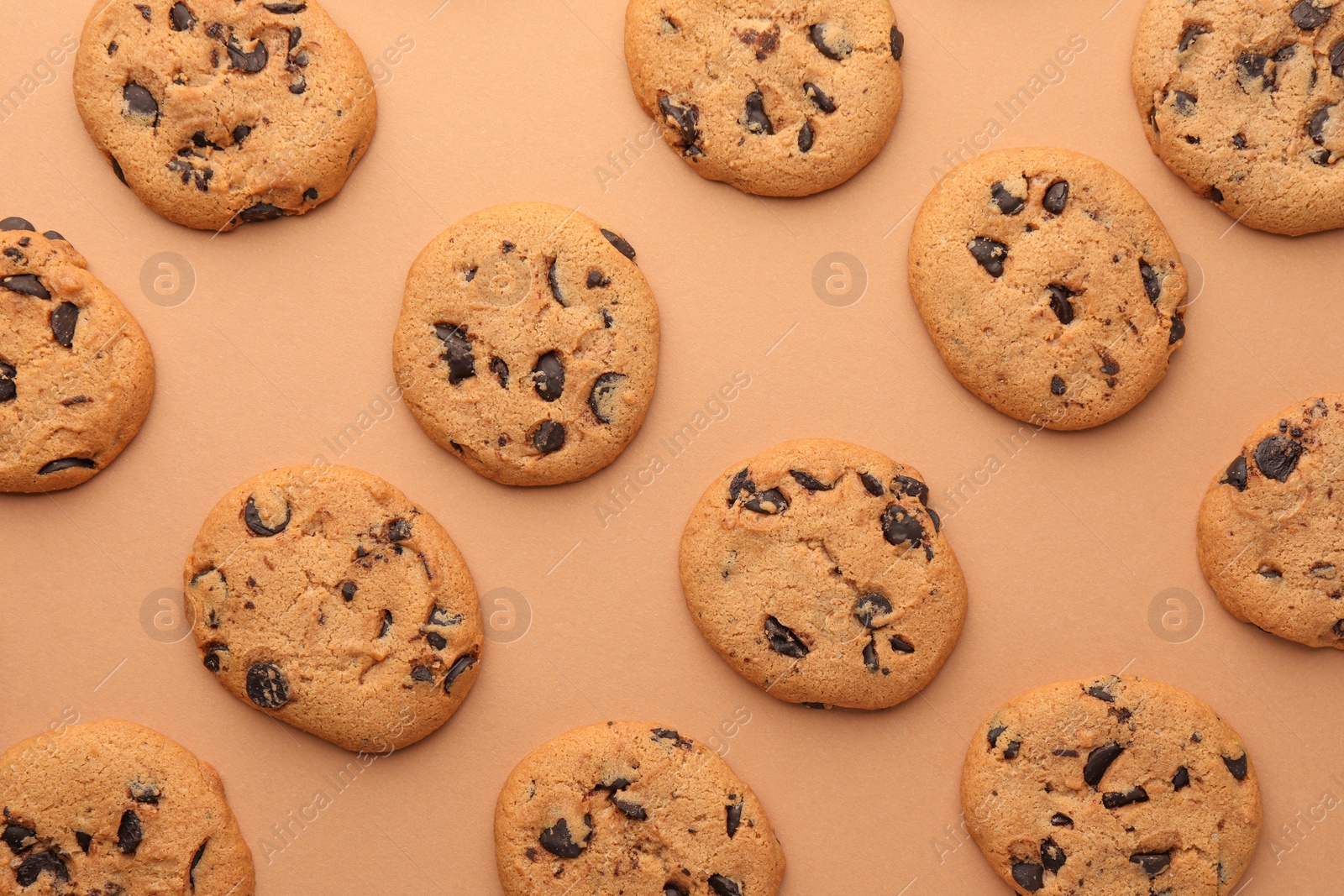 Photo of Many delicious chocolate chip cookies on beige background, flat lay