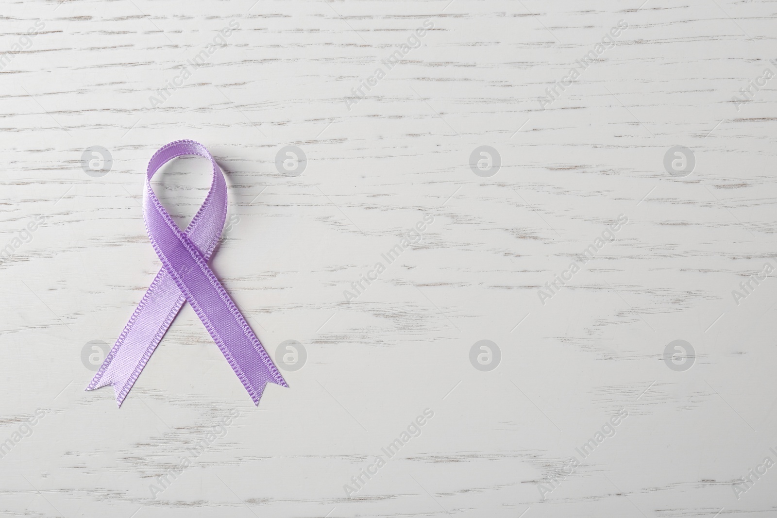 Photo of Purple ribbon on white wooden background, top view with space for text. Domestic violence awareness