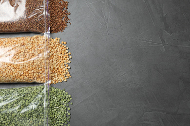 Photo of Flat lay composition with different types of legumes and cereals on dark grey table, space for text. Organic grains