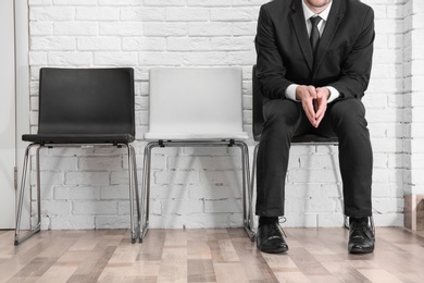 Young man waiting for job interview, indoors