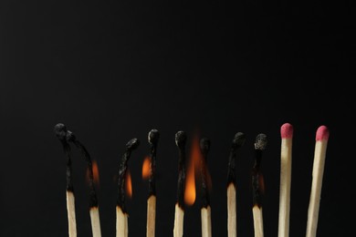 Photo of Burning and whole matches on black background, closeup. Stop destruction concept