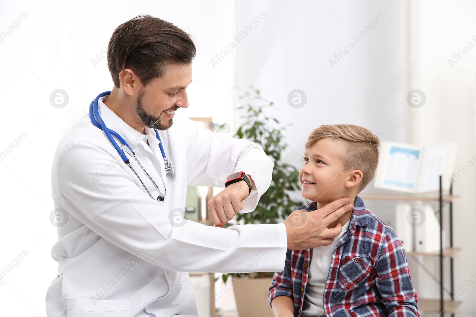 Photo of Doctor checking little boy's pulse with fingers in hospital