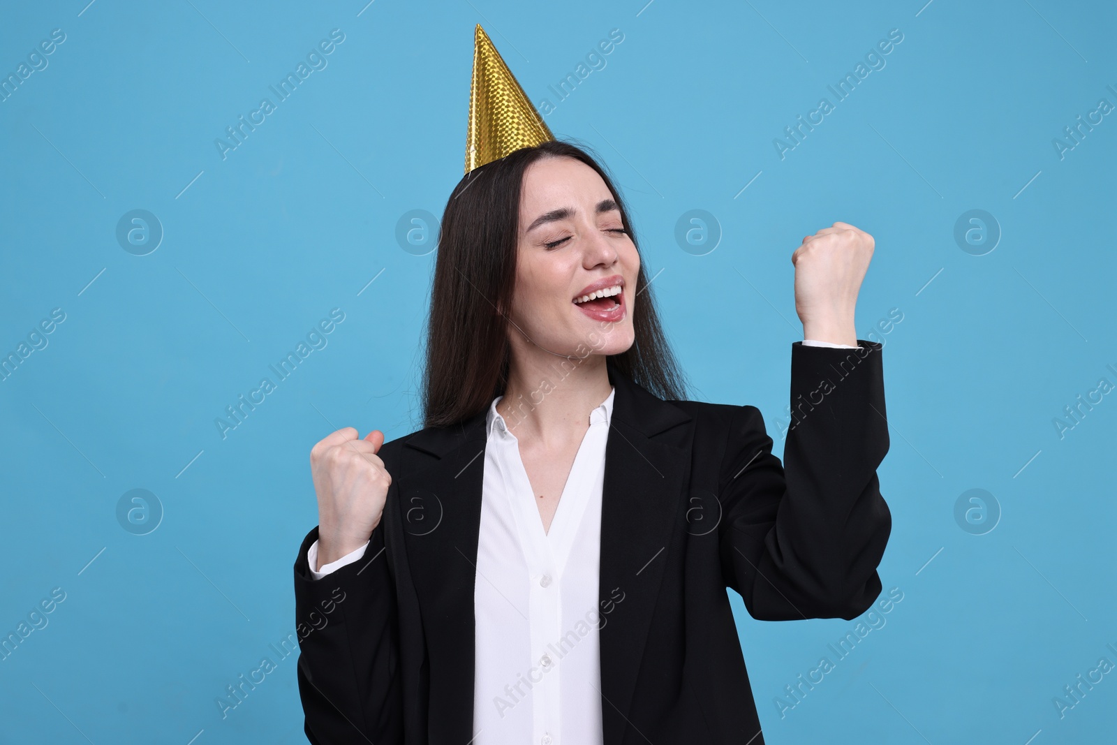 Photo of Happy woman in party hat on light blue background