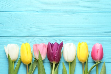 Photo of Flat lay composition of beautiful spring tulips on wooden background, space for text. International Women's Day