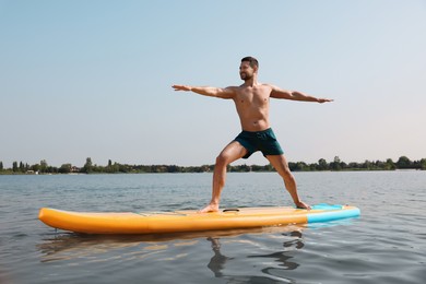 Photo of Man practicing yoga on SUP board on river