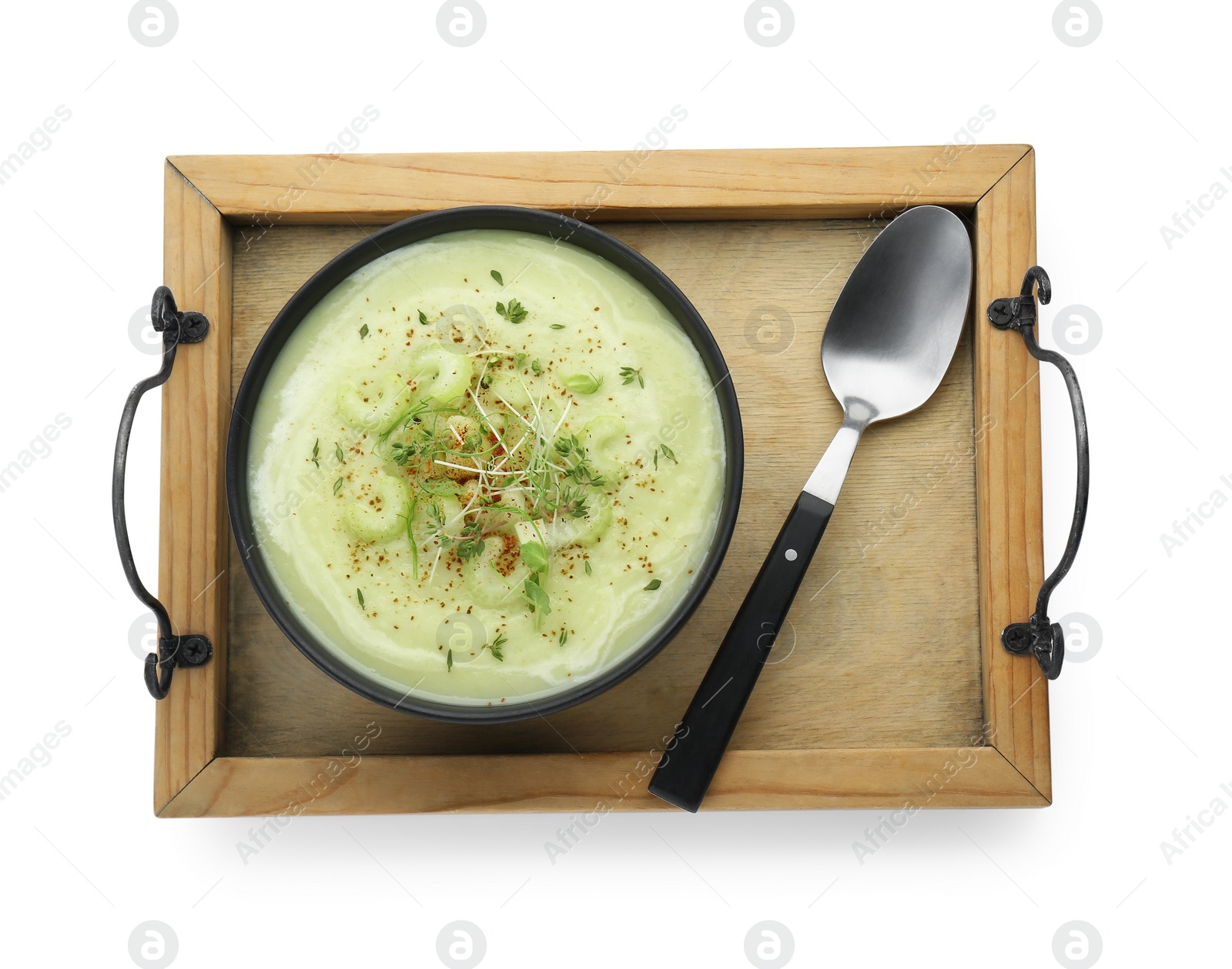 Photo of Wooden tray with bowl of delicious celery soup and spoon isolated on white, top view