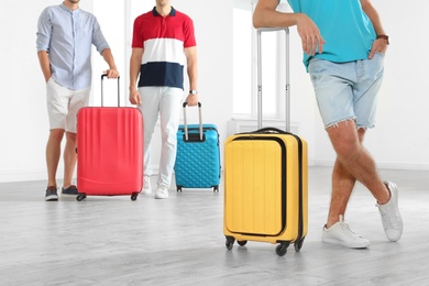 Group of young people with suitcases in light room, closeup