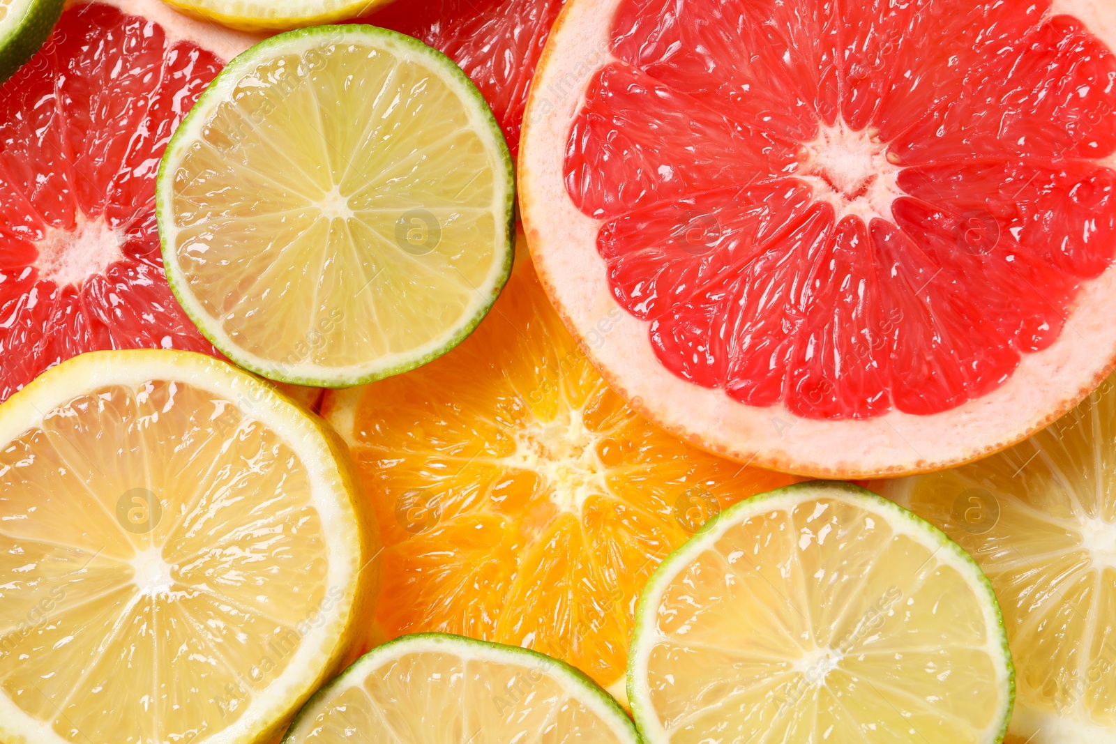 Photo of Different sliced citrus fruits as background, top view