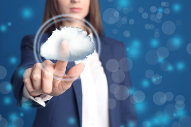 Image of Young woman working with virtual screen against blue background, focus on hand. Cloud technology