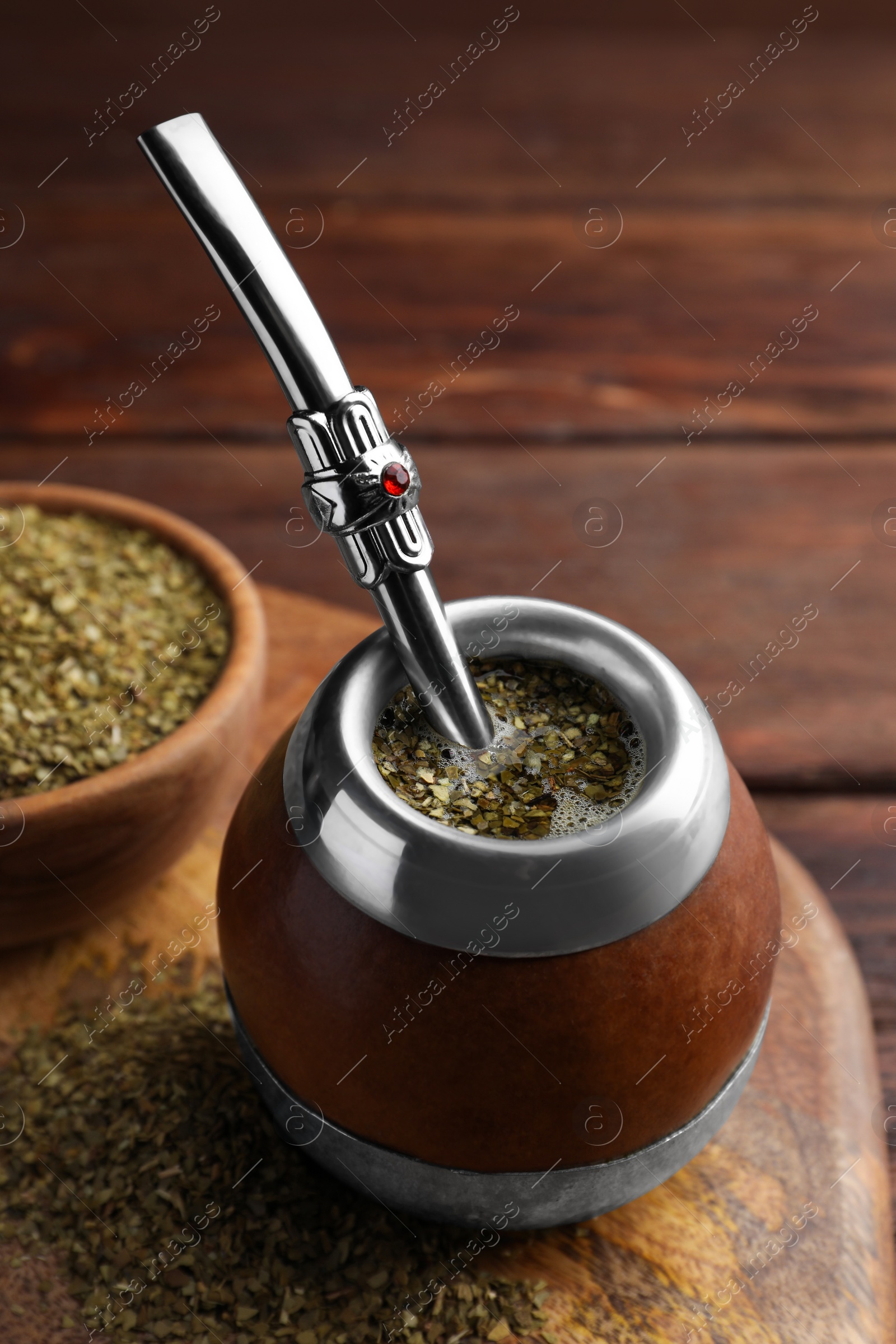 Photo of Calabash with mate tea and bombilla on wooden table