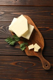 Photo of Tasty butter and parsley on wooden table, top view