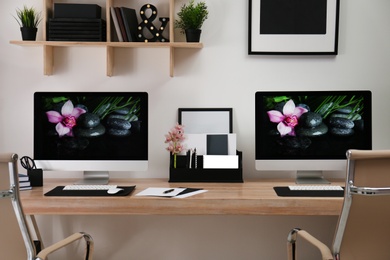 Modern workplace with large desk and computers in room. Stylish interior